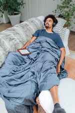 Novaline verzwaringsdeken met hoes bamboe blauw man slaapt op bank