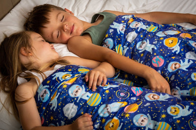 jongen en meisje op bed onder verzwaringsdeken