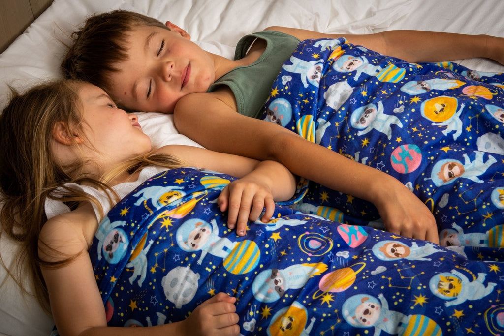 jongen en meisje op bed onder verzwaringsdeken