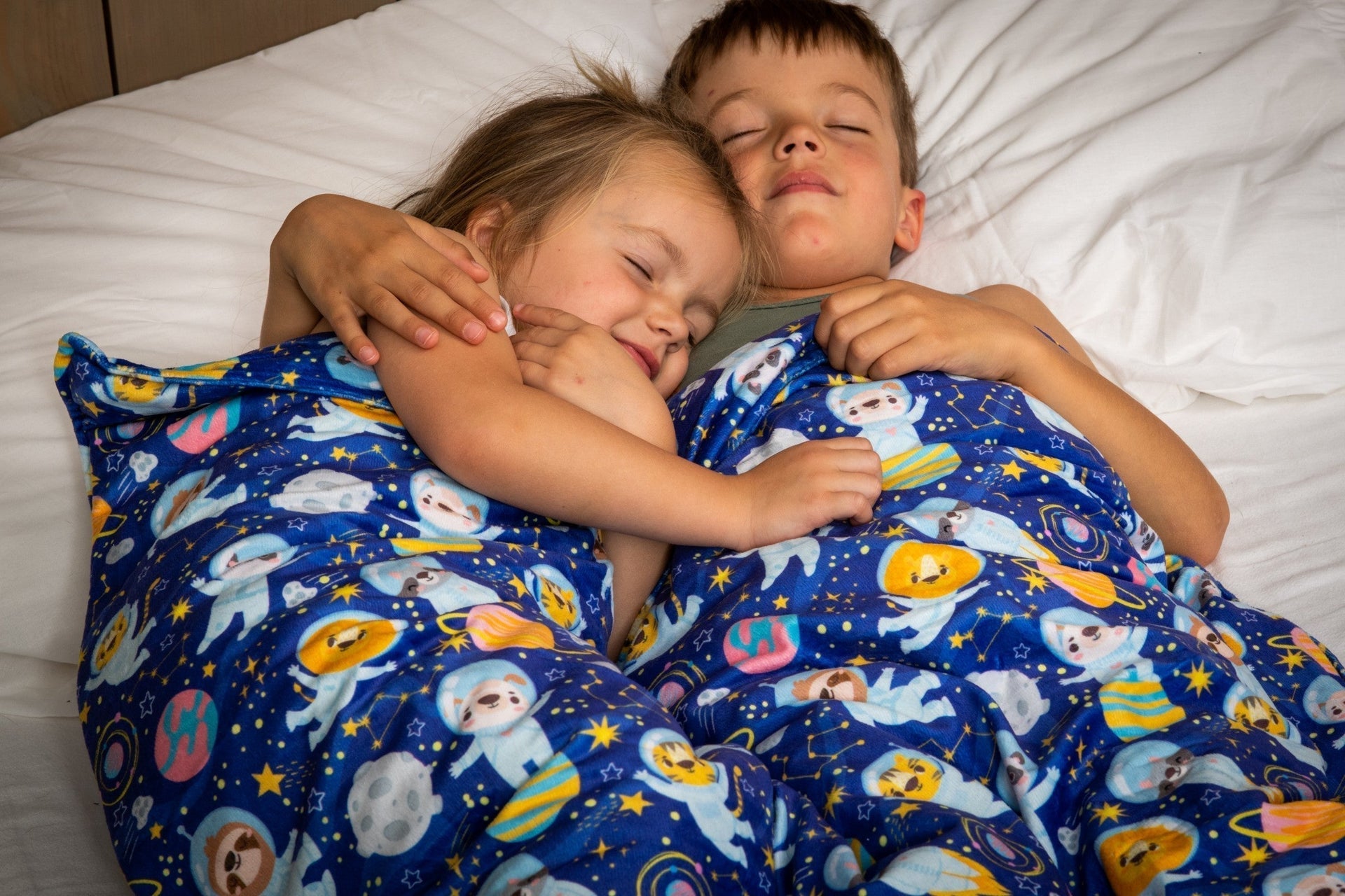 kinderen op bed onder verzwaringsdeken