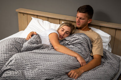 koppel op bed onder verzwaringsdeken