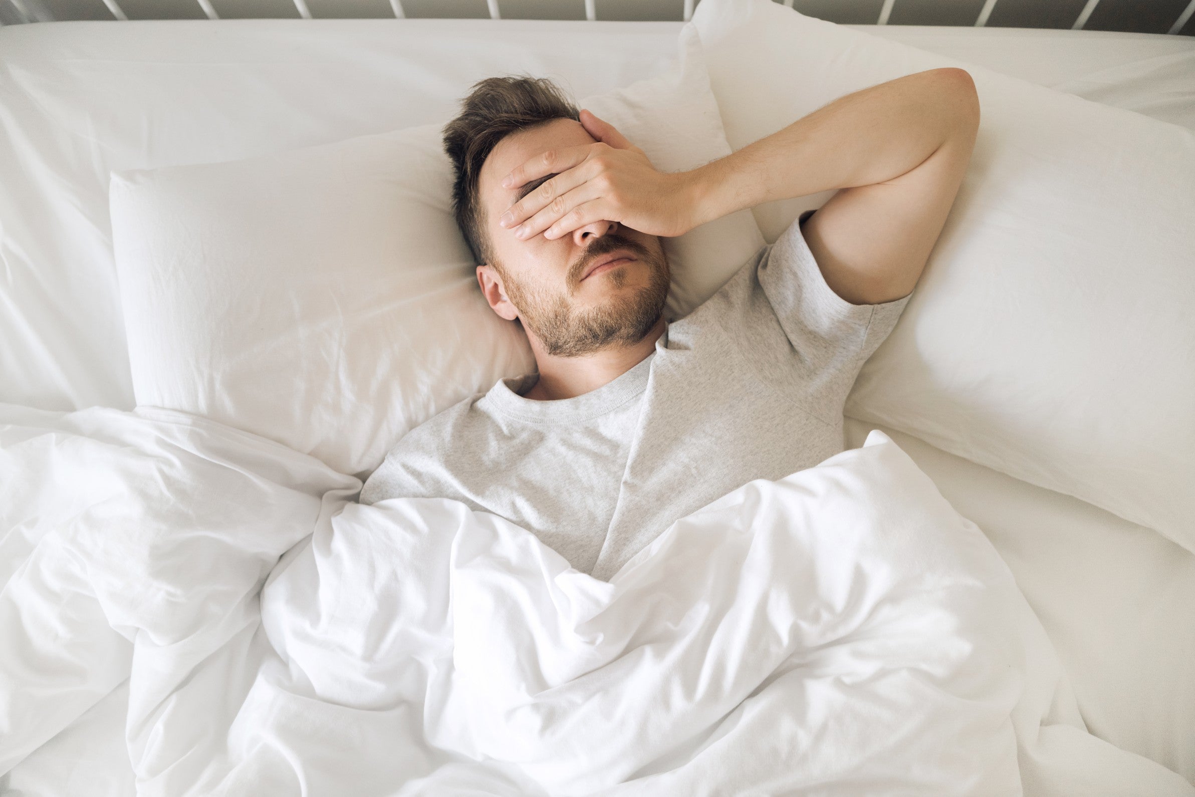 man ligt wakker op bed door burnout